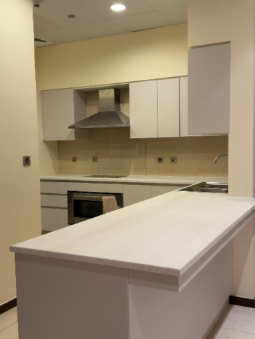white kitchen with wrapped cabinets and island countertop in Dubai