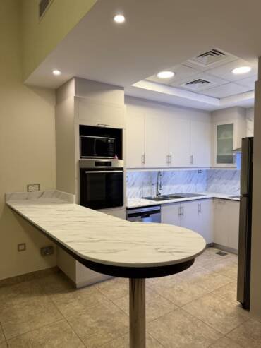 White kitchen with a contemporary vinyl wrap finish and marble-effect surfaces