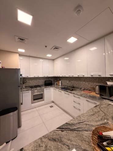 Modern kitchen makeover with updated cabinets and marble-effect surfaces in Dubai